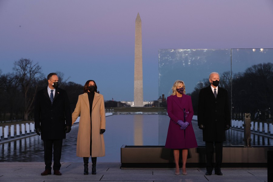 (L-R) Douglas Emhoff, U.S. Vice President-elect Kamala Harris, Dr. Jill Biden and U.S. President-elect Joe Biden attend a memorial service to honor the nearly 400,000 American victims of the coronavirus pandemic at the Lincoln Memorial Reflecting Pool January 19, 2021 in Washington, DC. As the nation's capital has become a fortress city of roadblocks, barricades and 20,000 National Guard troops due to heightened security around Biden's inauguration, 400 lights were placed around the Reflecting Pool to honor the nearly 400,000 Americans killed by COVID-19. Chip Somodevilla/Getty Images/AFP