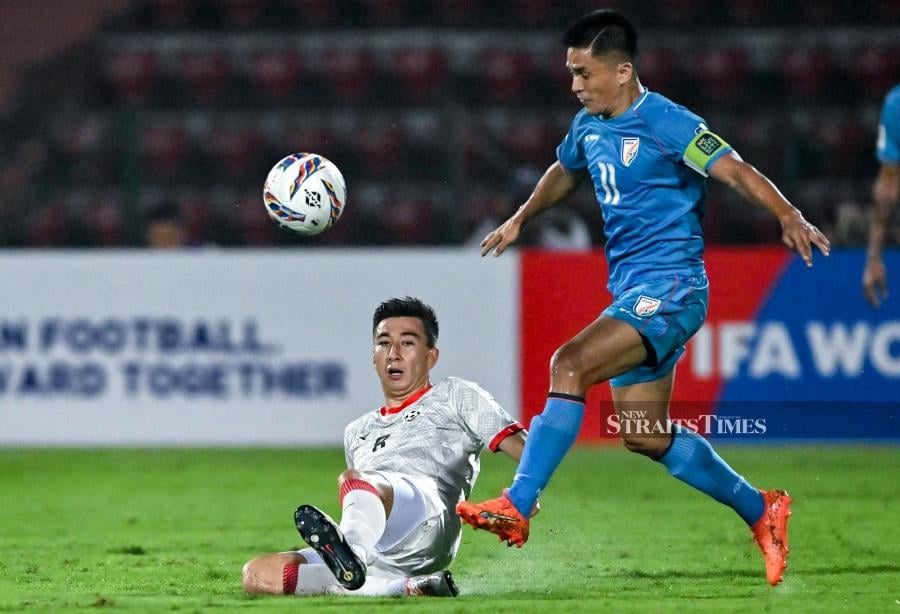 India's Sunil Chhetri (right) fights for the ball with Afghanistan's Rahmat Akbari during the World Cup AFC qualifier at the Indira Gandhi Athletic Stadium in Guwahati on March 26, 2024. AFP PIC