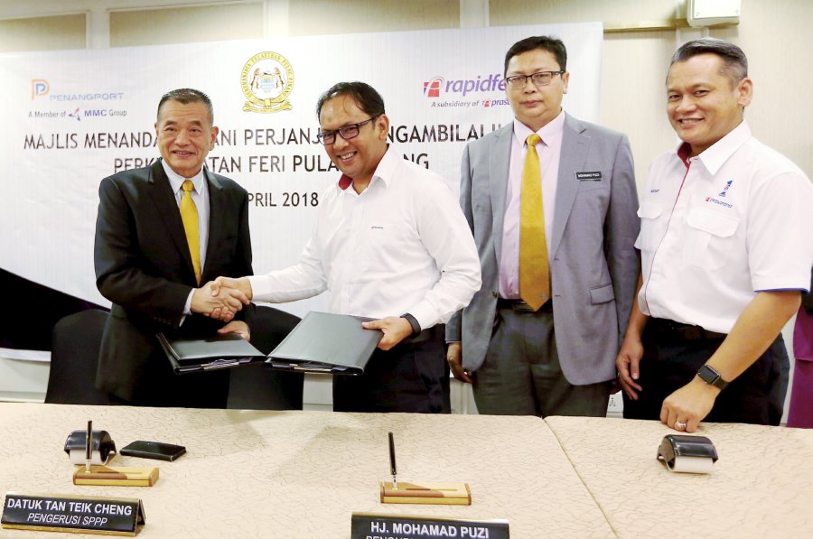 Penang Port Commission (PPC) chairman Datuk Tan Teik Cheng (left) exchanges the documents with Prasarana Malaysia Bhd chief financial officer Mohd Rafizee Abd Rahman (3rd from right) during the signing ceremony in Pengkalan Weld. Pic by MUHAMMAD MIKAIL ONG