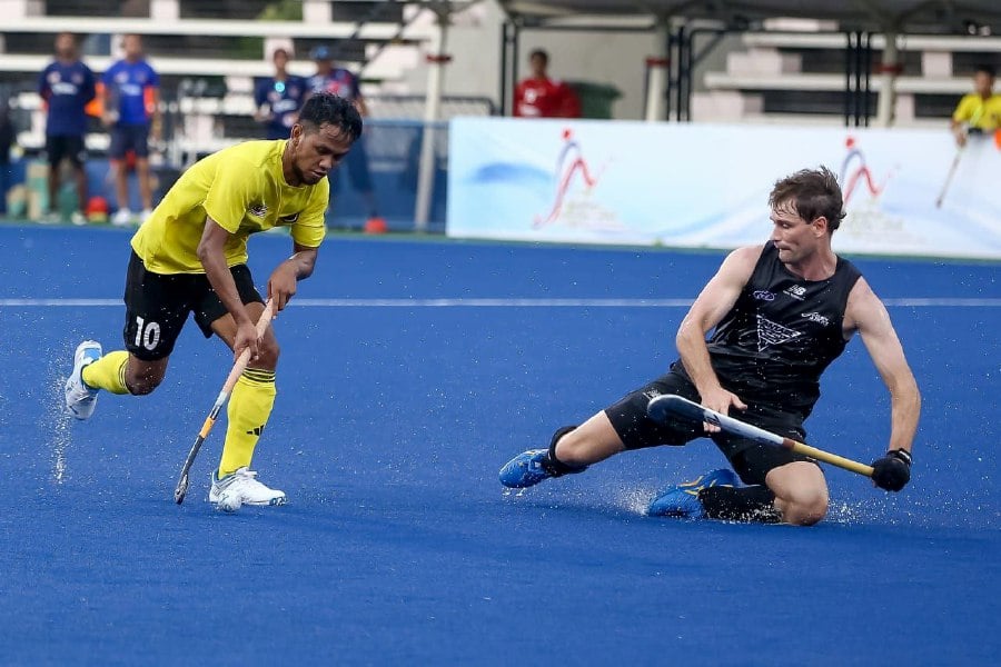 Malaysia's Faisal Saari (left) in action against New Zealand in today's friendly at Azlan Shah Stadium in Ipoh.