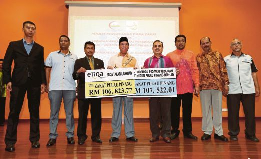 Datuk Mohd Salleh Man (centre) receiving zakat payments from Koperasi Pegawai Kerajaan Negeri Pulau Pinang chairman Ismit Yusof (second from right) and Etiqa Takaful Bhd northern regional manager Rosli Mohamed (second from left). Pic by Muhammad Mikail Ong