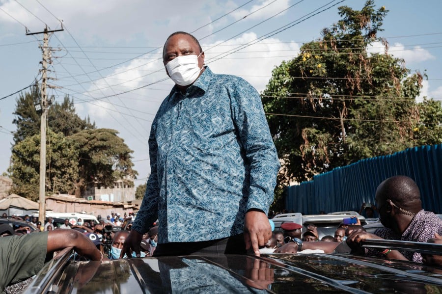 Kenya's President Uhuru Kenyatta listens to the speech of Kenya's opposition leader Raila Odinga after attending an inauguration of Kibra Level 3 hospital in Kibera slum in Nairobi on September 29, 2021. (Photo by Yasuyoshi CHIBA / AFP)