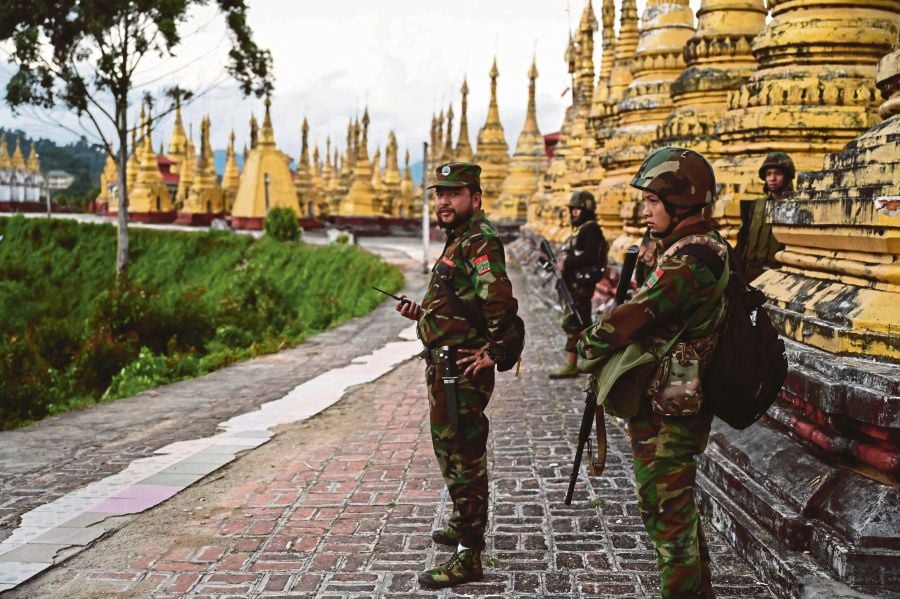 (FILES) Members of ethnic minority armed group Ta'ang National Liberation Army (TNLA) standing guard in a temple area of a hill camp seized from Myanmar's military in Namhsan Township in Myanmar's northern Shan State. (Photo by AFP) 