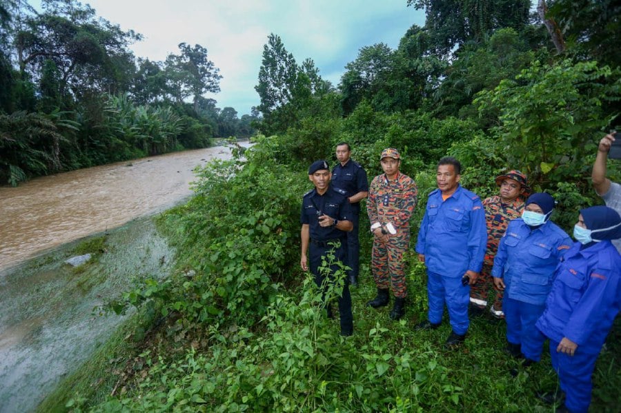 Rescuers from various agencies at the site where one of the drowned victims was found at Sungai Kenjur, Kampung Koh.- NSTP/MUHAMAD LOKMAN KHAIRI.