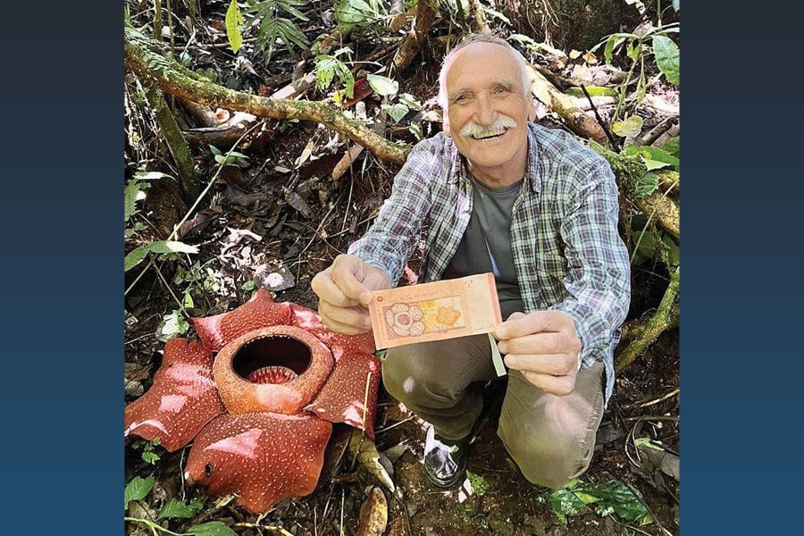 The writer holding a RM10 banknote beside a rafflesia. -Pic courtesy of the writer