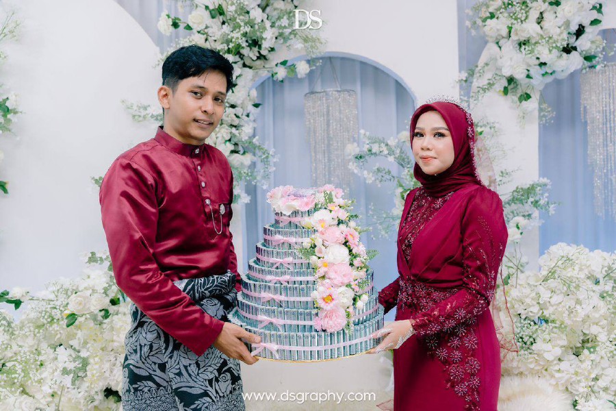 A “wang hantaran” of RM50,000 designed into a cake-shaped arrangement amused netizens who witnessed a couple’s engagement ceremony. - Pic courtesy Nur Izz Abdullah