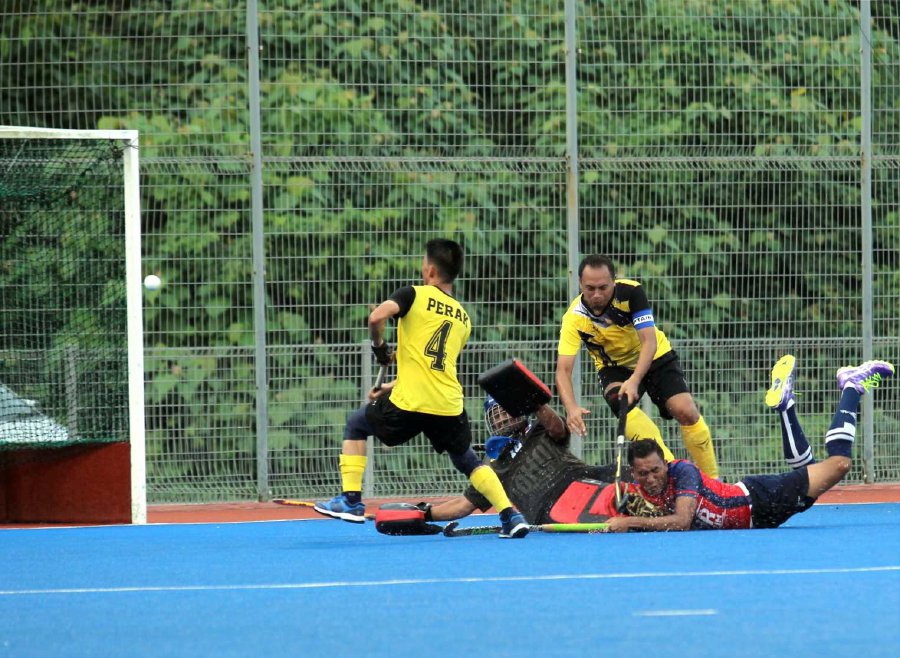 Johor’s Mohd Sofihuddin Ramli (2nd right) is challenged for the ball by Perak’s Affandy Mat Seruddin and teammates. Pic by MUHAMMAD ASYRAF SAWAL