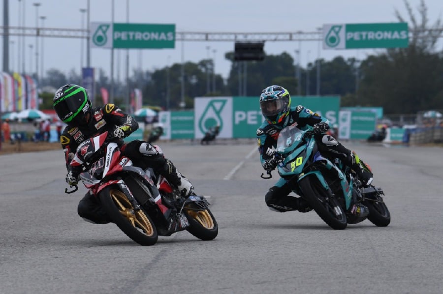 Azroy Hakeem Anuar (left) leads Ahmad Afif Amran during the Malaysian Cub Prix Championships in Terengganu yesterday.