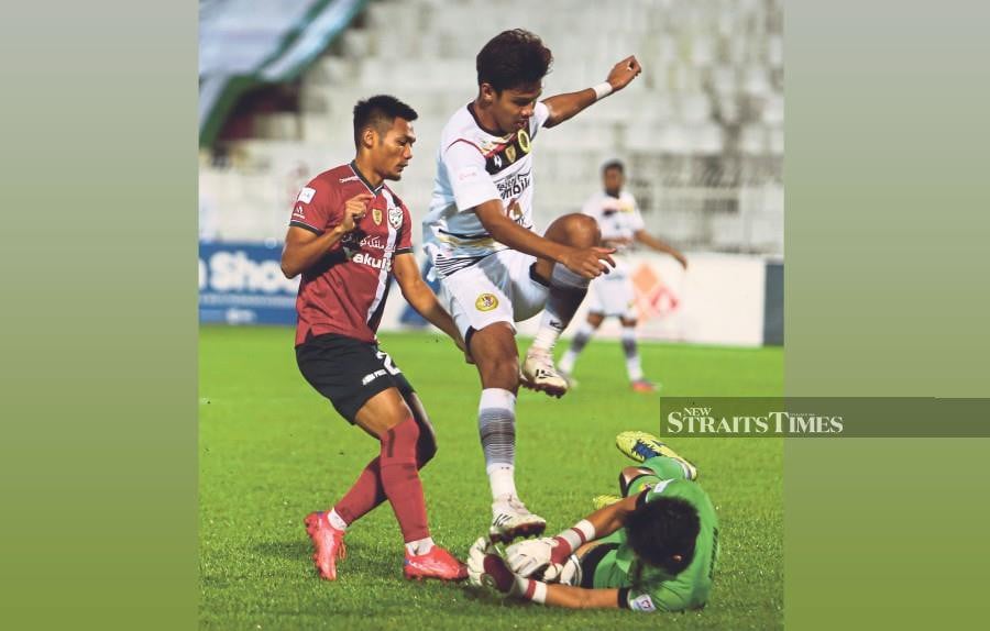 Negri Sembilan keeper Damien Chien takes the ball away from teammate Muhammad Zulkairi Zulkeply (centre) during their Malaysia Cup match with Kelantan United. -NSTP file pic, for illustration purpose only