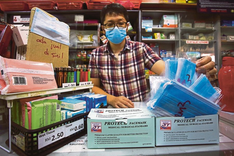 A shop owner  selling face masks at his store in the Terminal One bus station in Seremban yesterday. -Bernama