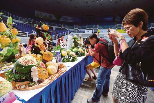 Visitors taking photos of the fruit carving. Pix by Muhammad Mikail Ong