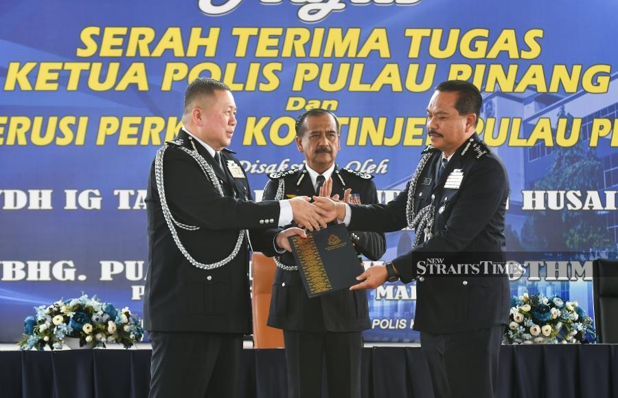 GEORGETOWN: Inspector-General of Police, Tan Sri Razarudin Husain (Centre) witnesses the handover of duties for the Penang police chief post between Datuk Khaw Kok Chin (left) and Datuk Hamzah Ahmad at the Penang police contingent headquarters here today (April 22). — NSTP / MIKAIL ONG