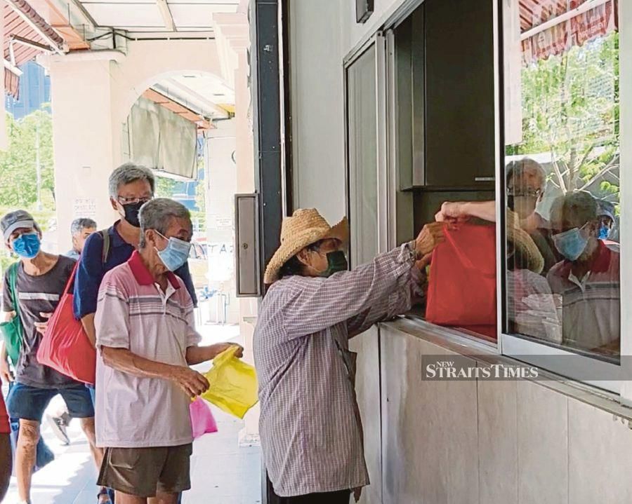 Elderly citizens lining up for food at the Kechara Soup Kitchen headquarters in Kuala Lumpur last week. At least 60 per cent of the recipients every Saturday are those aged 60 and above. -NSTP/IYLIA MARSYA ISKANDAR