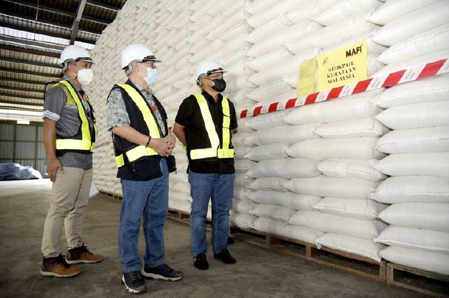 Agriculture and Food Industry Minister Datuk Seri Dr Ronald Kiandee (right) and his state counterpart Datuk Seri Dr Jeffrey Kitingan (centre) was pleased with the BERNAS stockpile management at the Telipok's warehouse. -Pic courtesy of MAFI