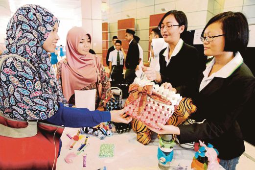 SMJK Phor Tay’s Eng Shu Wei (right) and Chan Ei Won (second from right) display the items that came up tops in the Best Product award category.