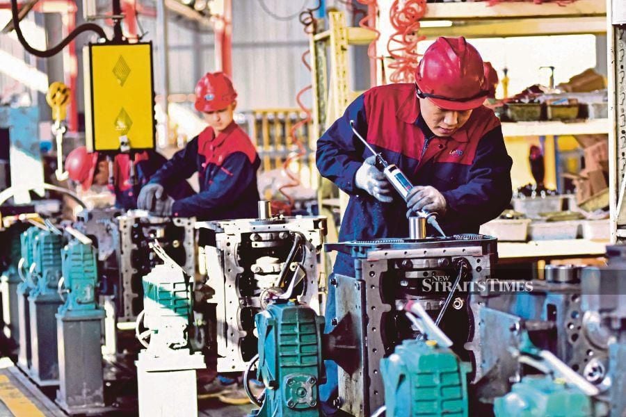 The overall demand conditions across the manufacturing sector remained muted at the end of 2023, leading firms to scale back production amid limited new order inflows, said S&P Global. (Photo by AFP) / China OUT