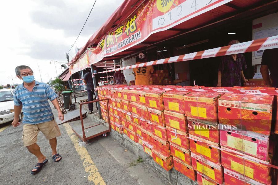 A man looking at boxes of mandarin oranges at a shop in Alor Star yesterday. -BERNAMA pic