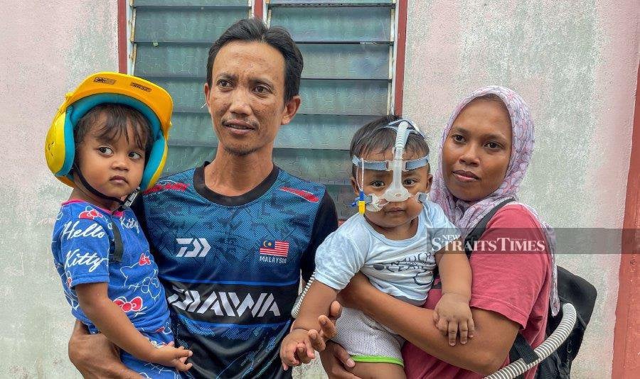  Mohd Aariz Zafran (second from right) with his mother Norhidayu Halim, 35, (right) and father Mohd Azlan Ishak, 35 (second from left) when met by reporters at their home in Taman Kota Nelayan, Kuala Kedah. - NSTP/ WAN NABIL NASIR
