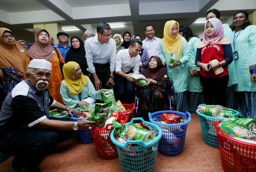 Lembah Pantai member of parliament Fahmi Fadzil handing over TNB’s contribution to underprivileged families at the Abdullah Hukum and Putra Ria Apartments, while TNB chief corporate officer Datuk Wira Roslan Ab Rahman looked on. Pix by Rosela Ismail
