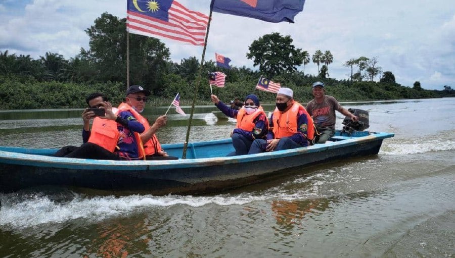 Najib (2nd from right) during the Merdeka boat ride along the Muar river.
