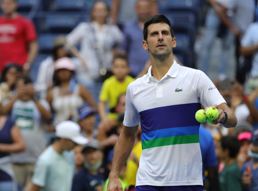 Serbia's Novak Djokovic hits balls into the crowd after defeating Japan's Kei Nishikori during their 2021 US Open Tennis tournament men's singles third round match at the USTA Billie Jean King National Tennis Center in New York. -AFP pic