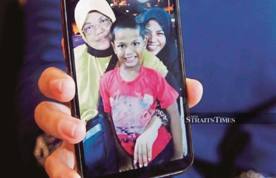 Zubaidi Amir Qusyairi Abd Malek’s adoptive mother, Norlida Abu Hassan, showing a picture they took together before he returned to his biological mother. - NSTP file pic