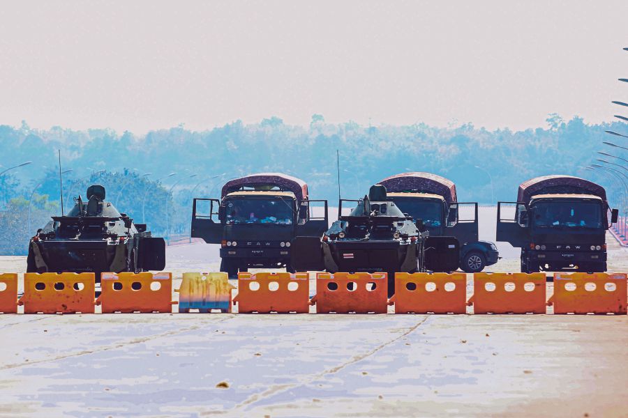 Military vehicles taking positions on a blockaded road near Myanmar’s Parliament in Naypyidaw yesterday. - AFP pic