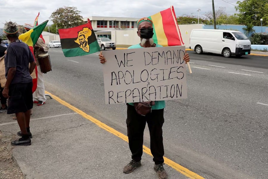 A protester holds a sign during a rally to demand that the United Kingdom make reparations for slavery, ahead of a visit to Jamaica by the Duke and Duchess of Cambridge as part of their tour of the Caribbean, outside the British High Commission, in Kingston, Jamaica. - Reuters pic