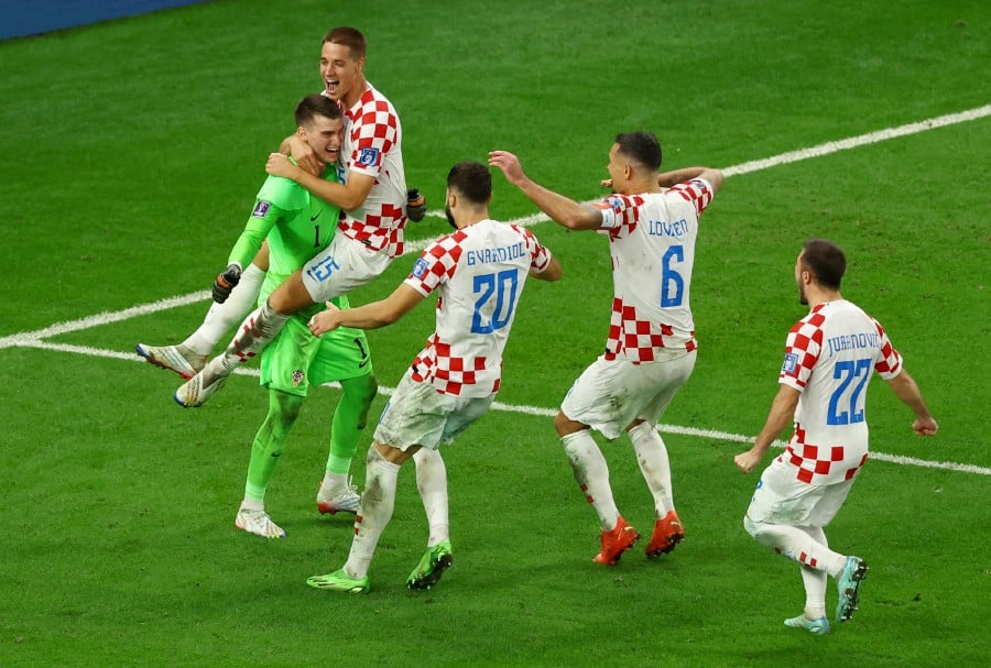 Croatia's Dominik Livakovic celebrates with Mario Pasalic, Josko Gvardiol, Dejan Lovren and Josip Juranovic after winning the penalty shootout and progressing to the quarter finals. -REUTERS PIC