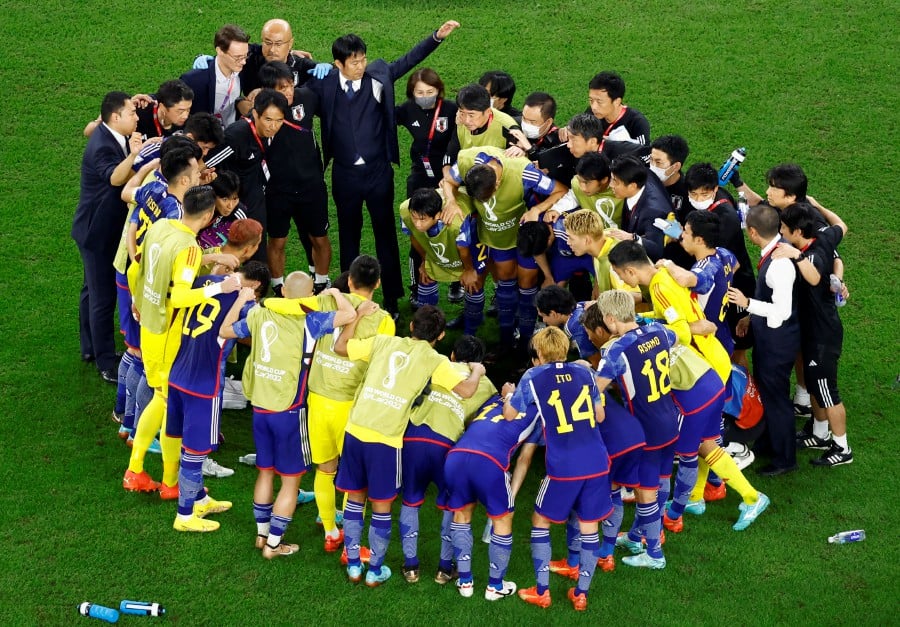 Japan coach Hajime Moriyasu, coaching staff and players in a huddle before the penalty shootout. -REUTERS PIC
