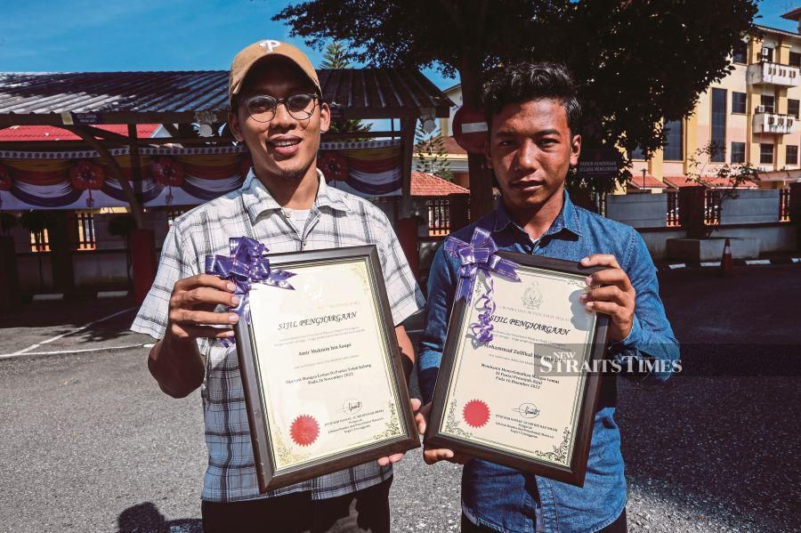 Amir Mukmin Saupi (left) and Mohd Zulfikal Asmadi receiving certificates of appreciation for assisting and rescuing drowning victims at the Terengganu Fire and Rescue Department’s annual gathering. NSTP/GHAZALI KORI