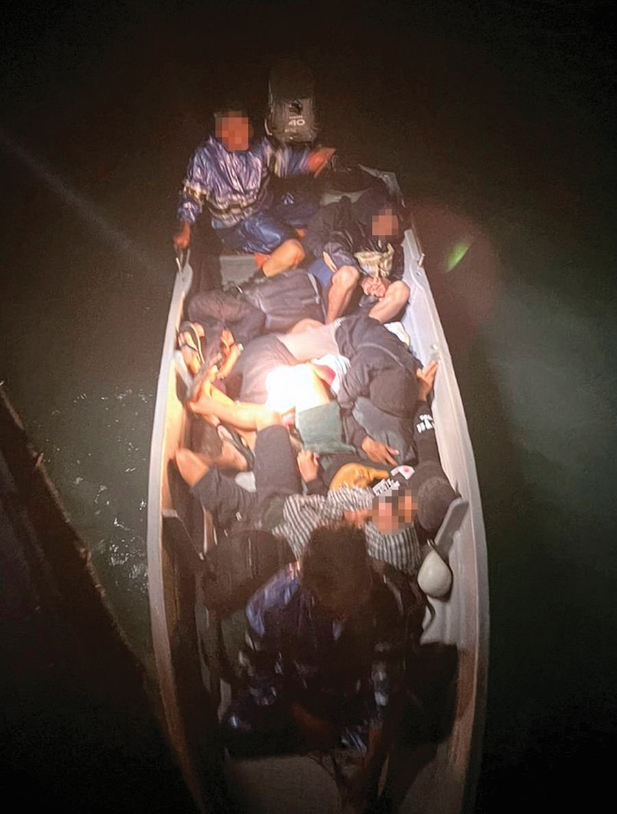  Some of the undocumented foreigners arrested by the Malaysian Maritime Enforcement Agency while travelling in waters off Johor, in various operations that include Op Benteng. PIC COURTESY OF MMEA