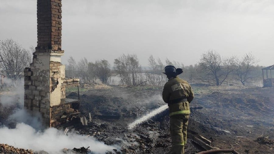 A firefighter works to extinguish a fire in the settlement of Bely Yar in the Krasnoyarsk region on May 7, 2022. -AFP PIC