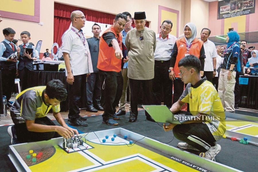 Deputy Prime Minister, Datuk Seri Dr Ahmad Zahid Hamidi (centre), observes participants competing in the Mobile Robotics Competition during National TVET Day 2024 at the Industrial Training Institute in Kuala Langat. STR / FAIZ ANUAR