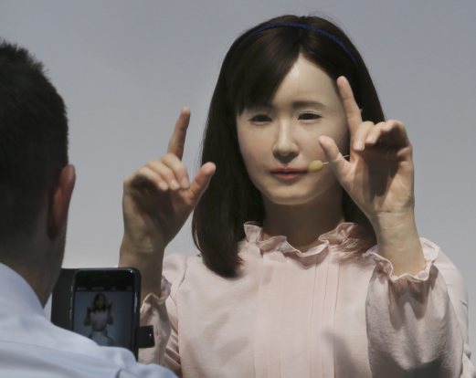 A prototype of Japanese electronics company Toshiba's female android Ms. Aiko Chihira performs sign language to a visitor during the annual CEATEC Japan advanced technologies show in Chiba Tuesday, Oct. 7, 2014. The robot features its smooth gestures and expressions, giving a self-introduction to visitors. Exhibitors used such attention-grabbing gadgets to showcase their technology and stand out at the event that started Tuesday.