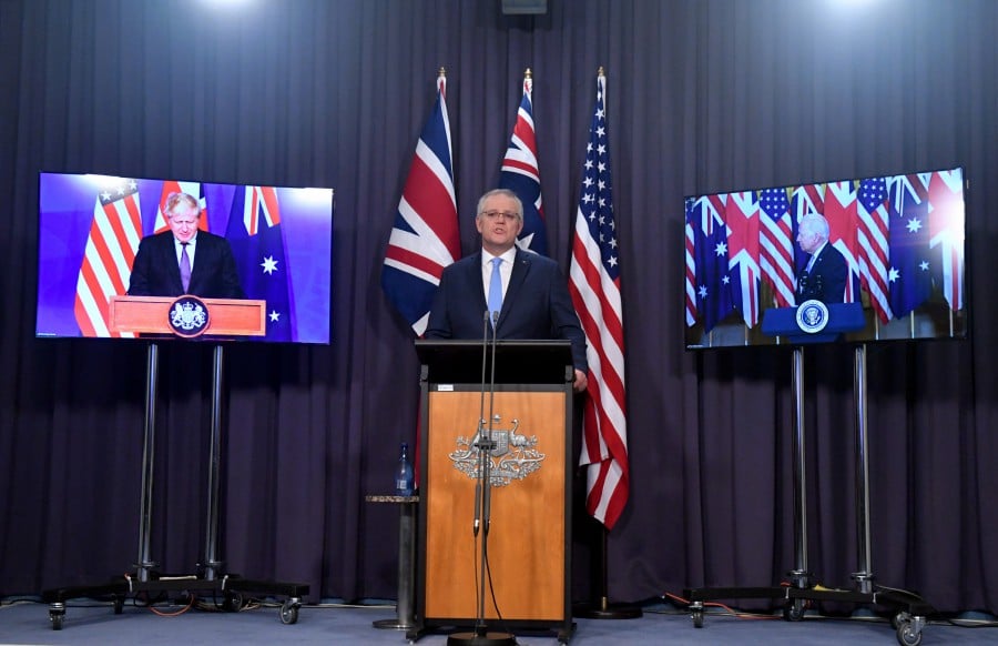 Britain's Prime Minister Boris Johnson, Australia's Prime Minister Scott Morrison (C) and US President Joe Biden attend a joint press conference via audio visual link (AVL) from The Blue Room at Parliament House in Canberra, Australian Capital Territory, Australia, 16 September 2021. Australia, the United Kingdom and the United States agreed to the creation of a trilateral security partnership to be known as AUKUS.