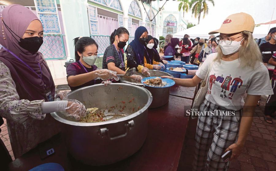 Volunteers serving food to break fast at Universiti Sains Malaysia’s Masjid Al-Malik Khalid, in George Town on Wednesday. -NSTP/DANIAL SAAD