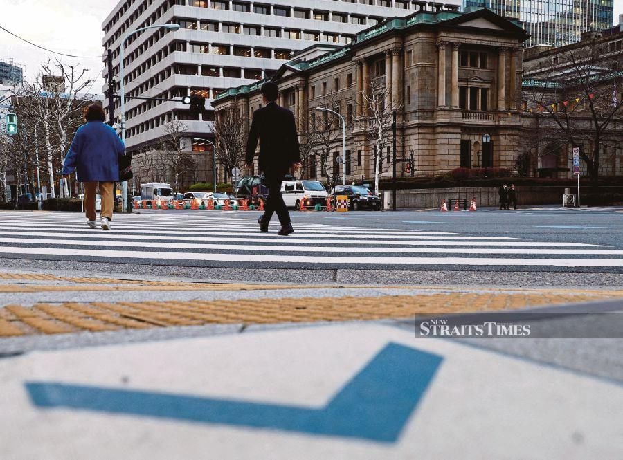 People walk in front of the Bank of Japan building in Tokyo, Japan. REUTERS/Kim Kyung-Hoon/File Photo