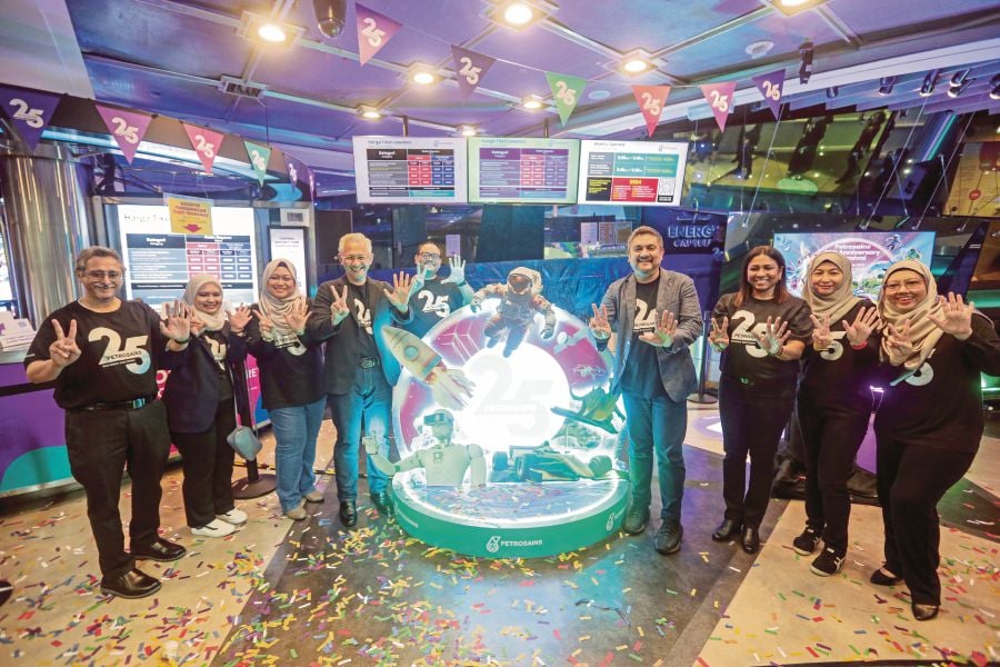 Petrosains CEO Ezarisma Azni Mohamad (fourth from left) and board member Syed M Muhafiz Syed M Bakar (fourth from right) launching the Petrosains 25th Anniversary Carnival. (Inset) Visitors checking out one of the many attractions. PIX BY HAZREEN MOHAMAD