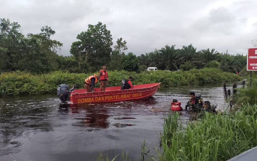 Divers from the Fire and Rescue department’s Water Rescue Unit scour the ditch at Sungai Bebar Utara oil palm plantation in Pekan. PIC COURTESY OF FIRE AND RESCUE DEPT