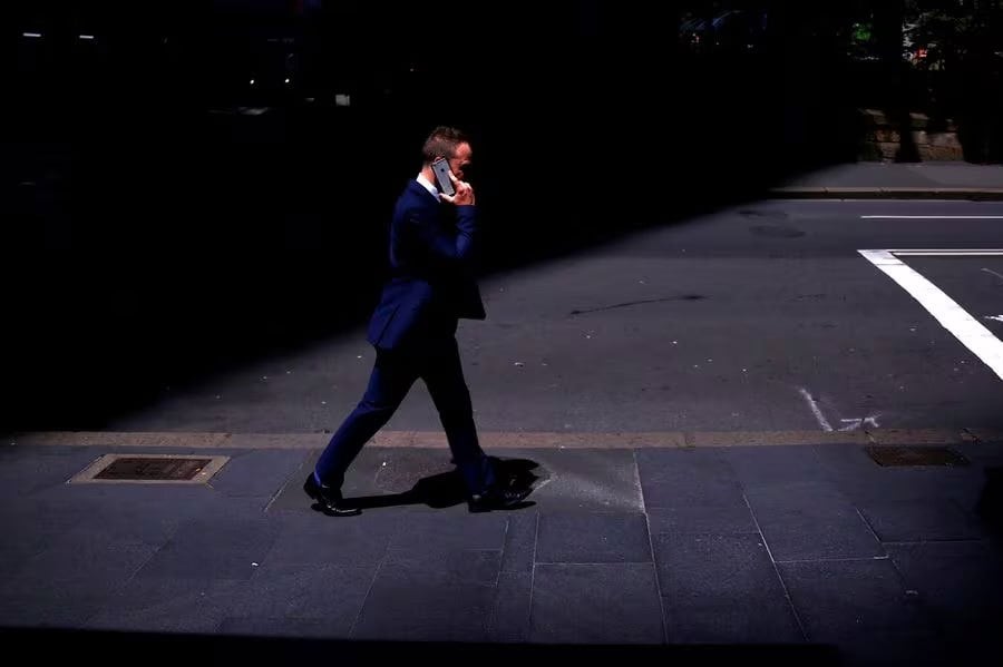A businessman talks on his Apple iPhone as he walks along a street in the central business district (CBD) of Sydney in Australia, October 24, 2017. REUTERS FILE PIC