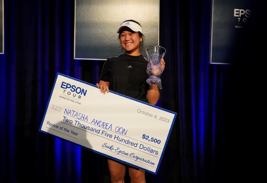 An overjoyed Natasha Andrea Oon pose with the Epson Tour’s Rookie of the Year trophy and mock cheque at the season-ending Epson Tour Championship in Florida on Sunday. PIC FROM Natasha Andrea Oon