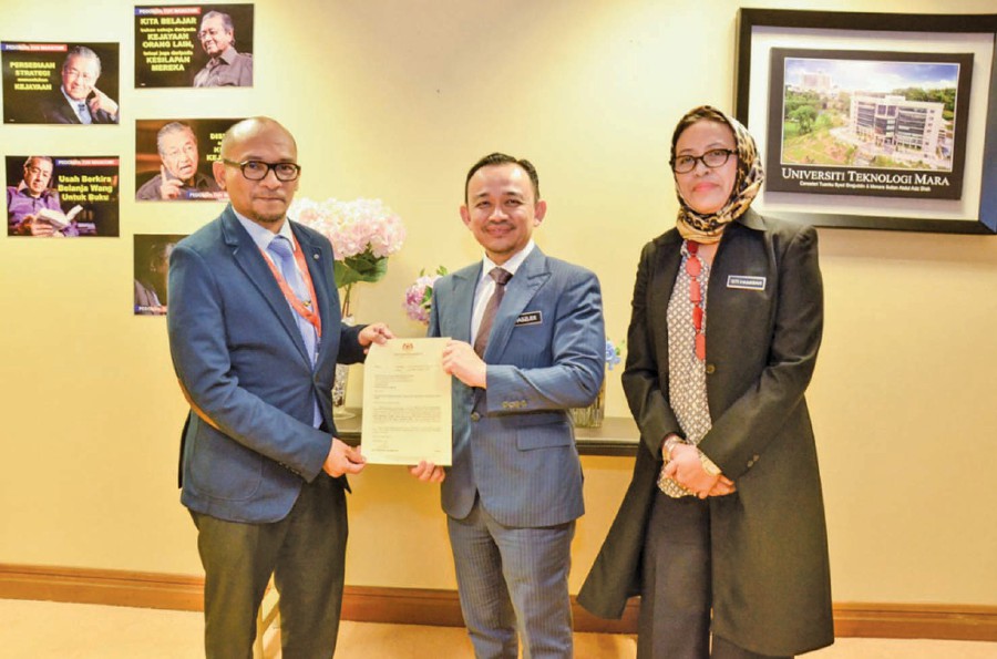 Dr Maszlee Malik presenting the letter of appointment to Professor Dr Faisal Rafiq Mahamd Adikan (left) as the new vice-chancellor of Universiti Sains Malaysia. Looking on is Higher Education director-general Dr Siti Hamisah Tapsir.