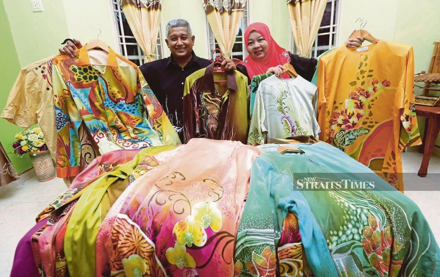 Zainal Ariffin Zainuddin and his wife, Narihas Abd Rahman, with their batik collection at their home in Gong Badak. PIC BY GHAZALI KORI 