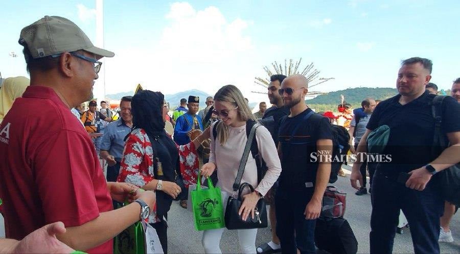Langkawi Development Authority (Lada) chief executive officer Datuk Haslina Abdul Hamid (second from left) accompanied by Langkawi District Officer Mohamad Subhi Abdullah (left), presenting souvenirs to passengers of flydubai’s inaugural flight to Langkawi. NSTP/HAMZAH OSMAN