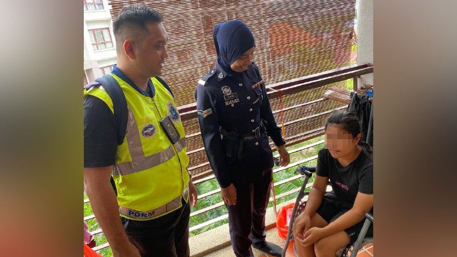 Police from the federal Anti-Trafficking in Persons and Smuggling of Migrants Division speaking to the Indonesian domestic helper who endured a week being locked up on the balcony of a condominium unit. Pic courtesy of police