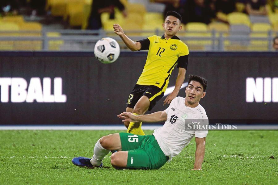 Malaysia’s Arif Aiman Hanapi (left) and Turkmenistan’s Saparmammedov Yhlas vie for the ball in Wednesday’s Asian Cup Group E qualifier at the National Stadium. - NSTP/AIZUDDIN SAAD