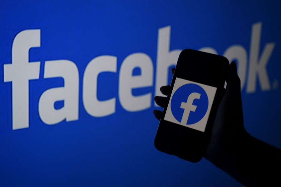 A smart phone screen displays the logo of Facebook on a Facebook website background in Arlington, Virginia - Facebook on October 8, 2021 said some users were having problems accessing its services, just days after a massive outage. -AFP PIC