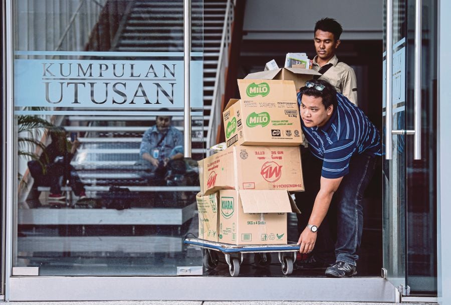 ‘Utusan Malaysia’ employees pushing boxes of their belongings out of the office in Kuala Lumpur yesterday. BERNAMA PIC 