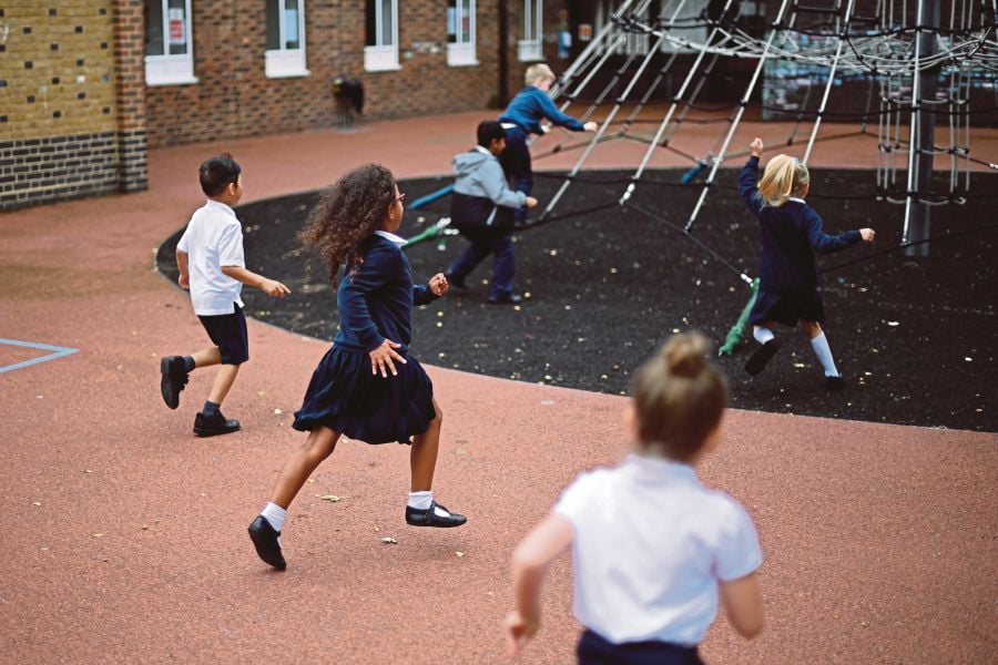 Pupils playing during a break at a school in East London. AFP PIC